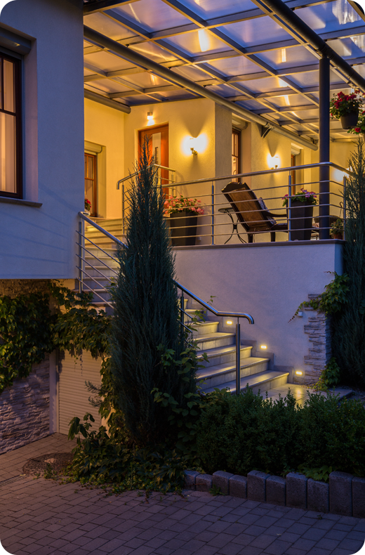 Beautiful installation of permanent outdoor lighting on porch and stairs.